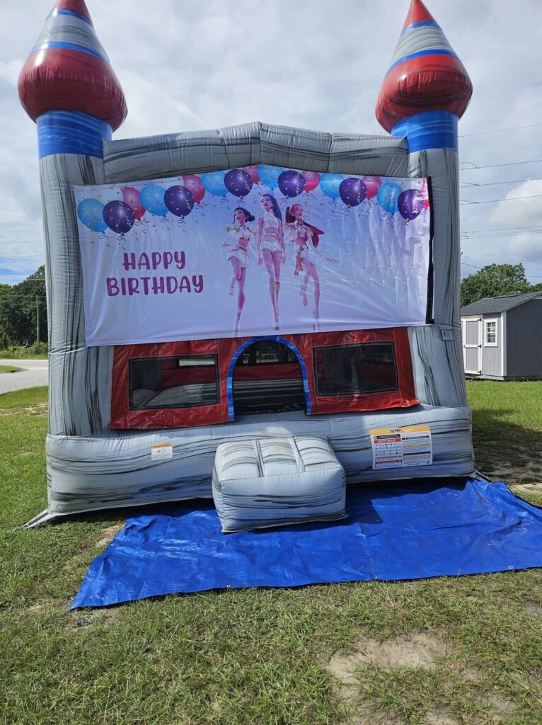 Grey castle bounce house with a Happy Birthday banner