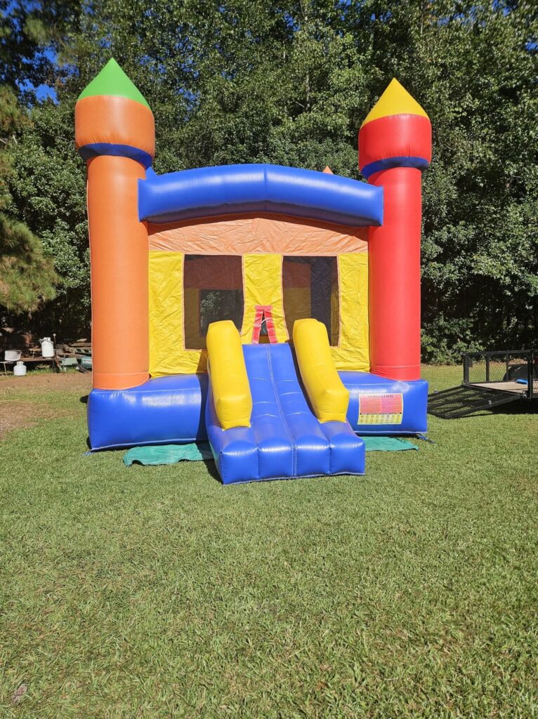 Orange, yellow, blue and red castle bounce house with slide